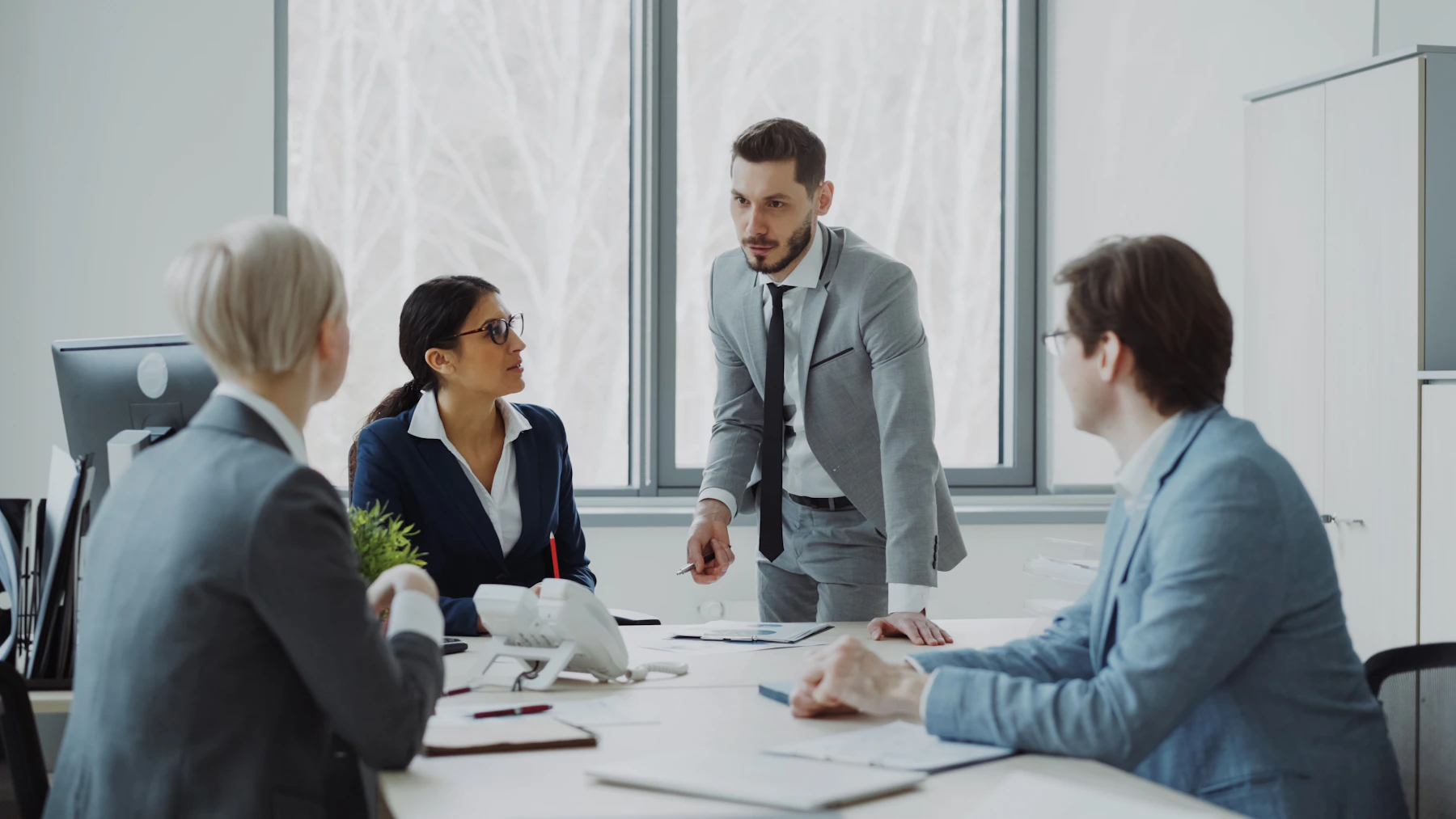 Equipe de gestão reunida discutindo processos e indicadores de qualidade em uma sala corporativa